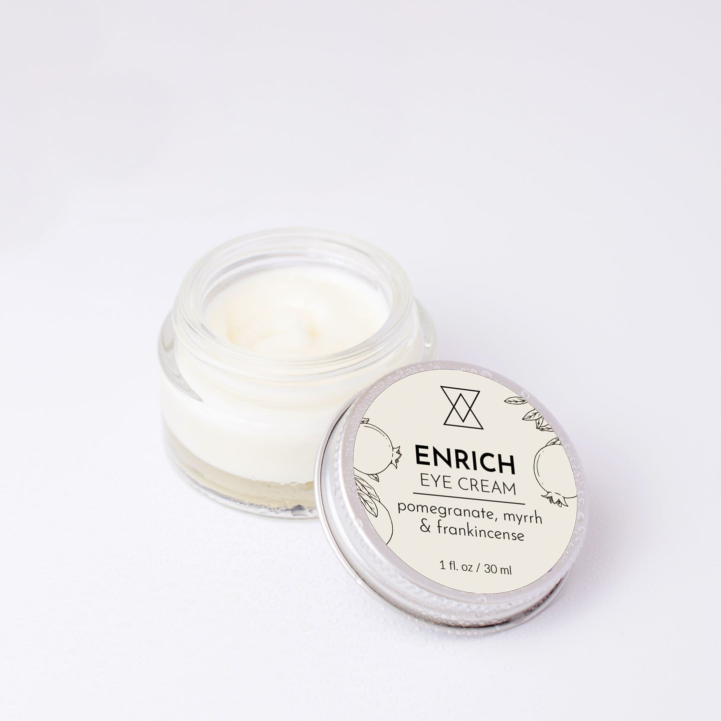Enrich Eye Cream open jar with lid on a white background
