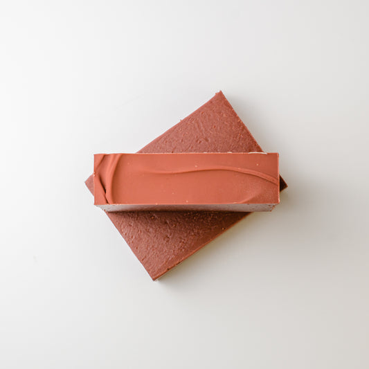 Two terracotta-colored soap bars on a light gray background