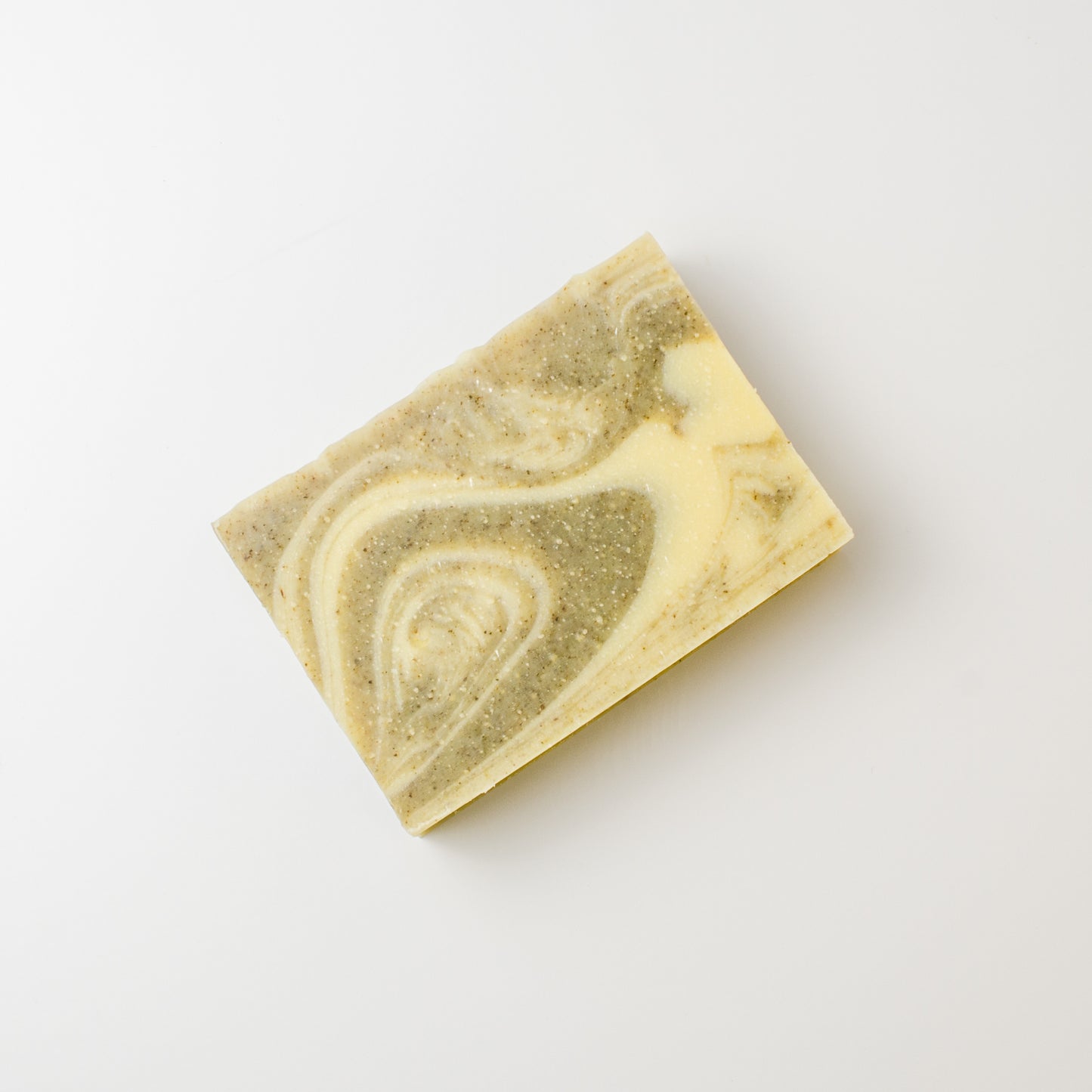 Marbled soap bar with green and beige swirls on a white background