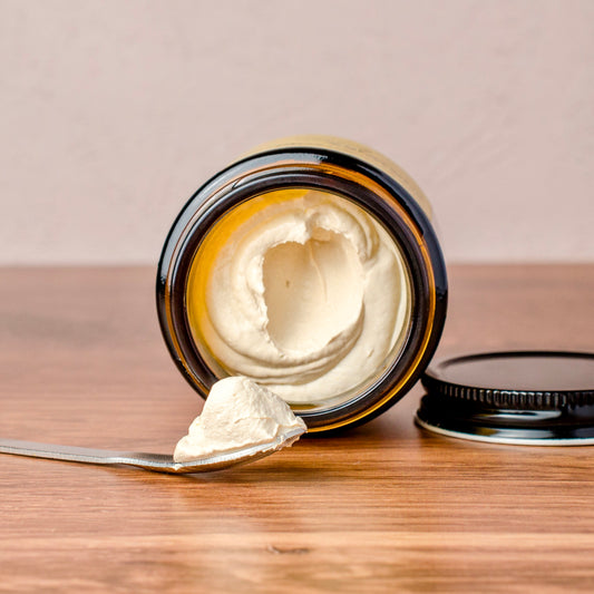 Jar of zinc oxide cream with a spoonful on a wooden surface