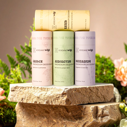 Four Verdant Wild deodorant containers on a stone surface with a natural background