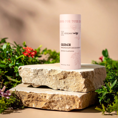 Verdant Wild Garden deodorant tube on a stone surface with greenery in the background