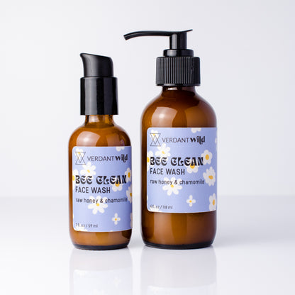 Two amber glass face wash bottles with black pumps on a white background. The smaller bottle has a black treatment pump, and the larger bottle has a bigger black pump.