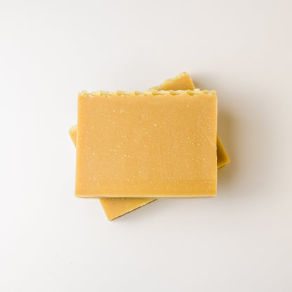Two yellow soap bars stacked on a white background