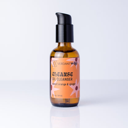 A 2 oz amber glass bottle of Verdant Wild Cleanse Oil Cleanser with a black pump dispenser and an orange label, set against a clean white background with a soft reflection.
