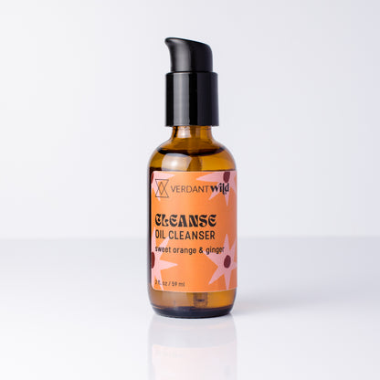 A bottle of Verdant Wild Cleanse Oil Cleanser with a black pump and amber glass bottle, featuring a peach and orange label with graphics, set against a clean white background.