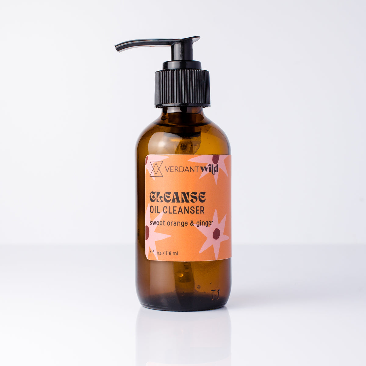 A bottle of Verdant Wild Cleanse Oil Cleanser in a dark amber glass bottle with a black pump dispenser and an orange label, set against a clean white background.