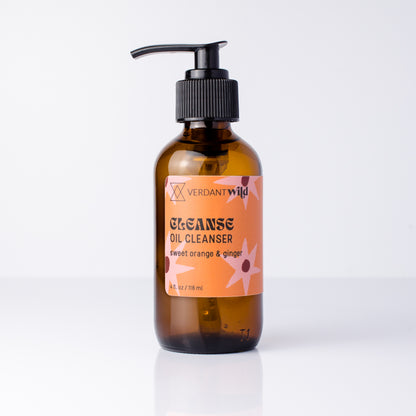 A bottle of Verdant Wild Cleanse Oil Cleanser in a dark amber glass bottle with a black pump dispenser and an orange label, set against a clean white background.