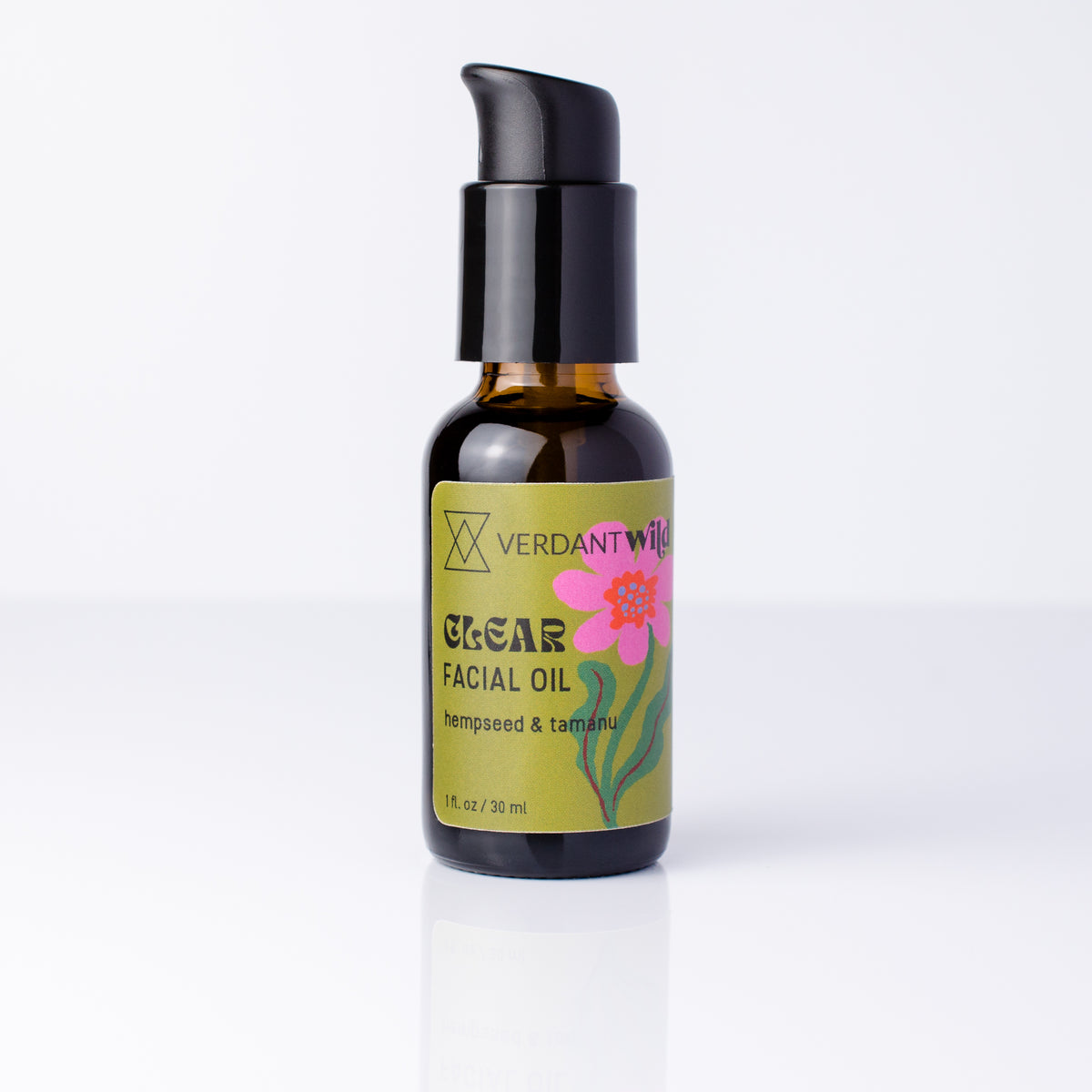 A 30 ml amber glass bottle of Verdant Wild Clear Facial Oil with a black pump dispenser and a green label featuring a pink flower, set against a clean white background.