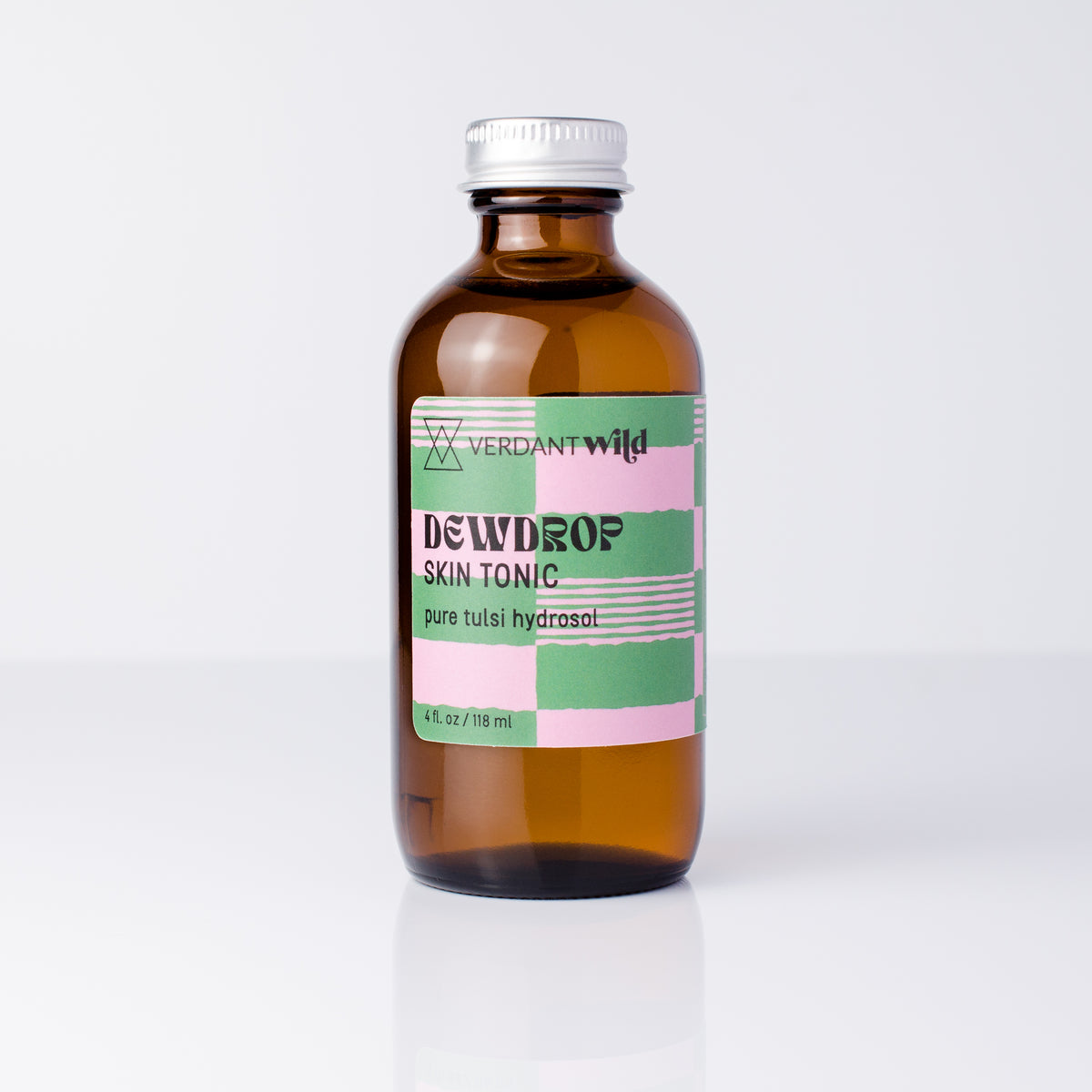 An amber glass bottle of Verdant Wild Dewdrop Skin Tonic with a silver cap and a pink, green, and white label, set against a clean white background.