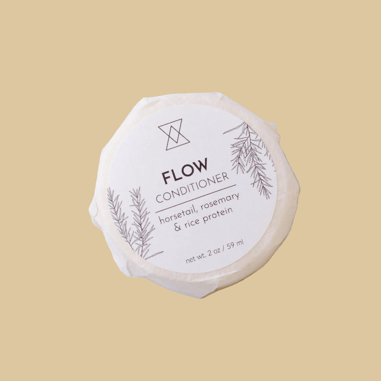A round, unbleached soap bar wrapped in paper with a white label reading 'FLOW CONDITIONER' and 'horsetail, rosemary & rice protein' on a clean background.