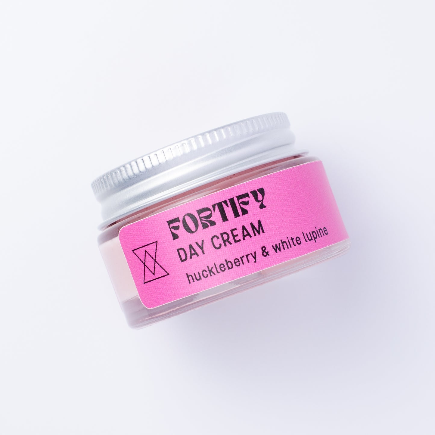 A small clear jar of Fortify Day Cream with a silver lid and a bright pink label, photographed on a clean white background.