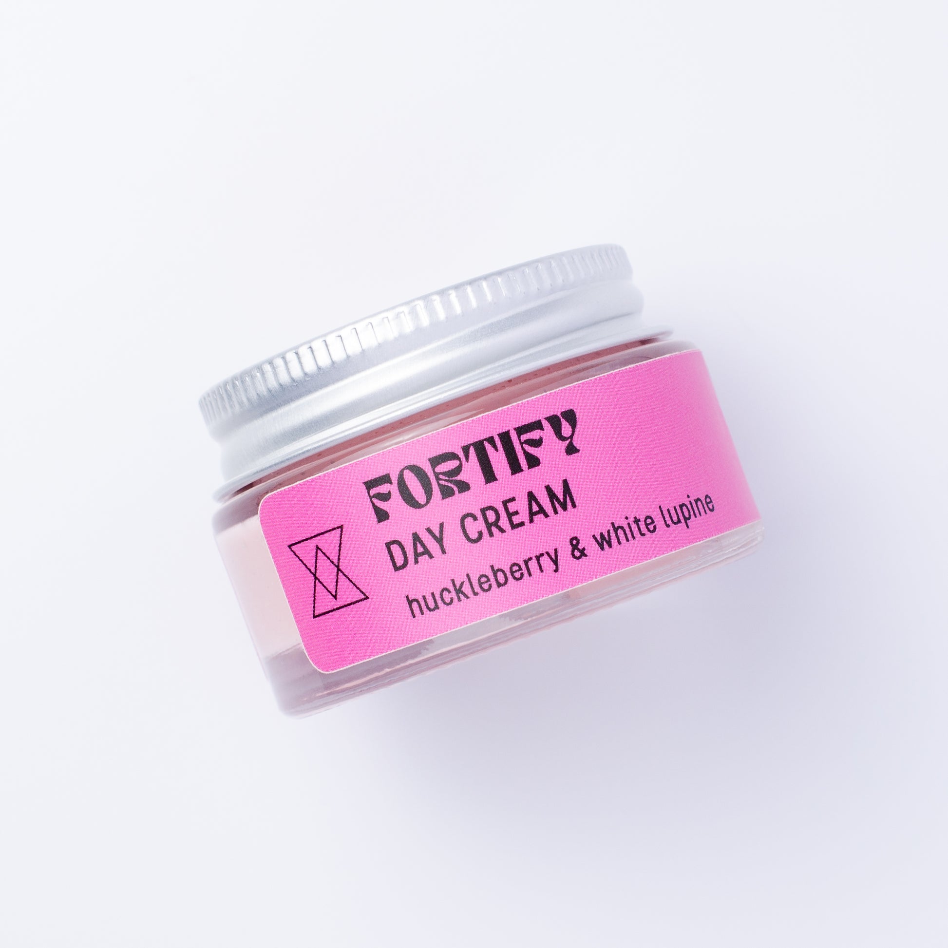 A small clear jar of Fortify Day Cream with a silver lid and a bright pink label, photographed on a clean white background.