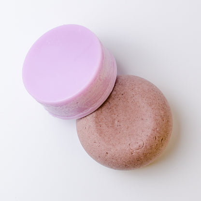Two round hair shampoo and conditioner bars on a clean white background