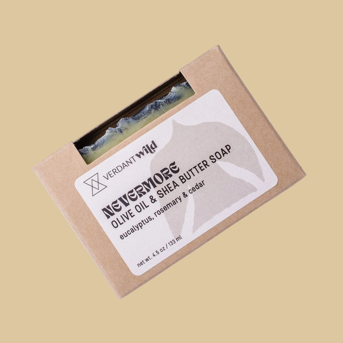 A bar of soap in a kraft paper sleeve with a white label reading 'NEVERMORE OLIVE OIL & SHEA BUTTER SOAP', shown on a plain beige background.