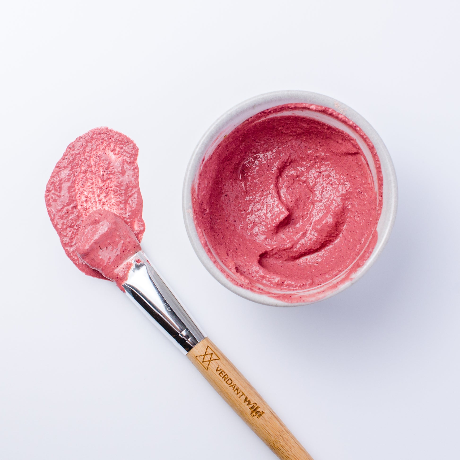 Nourish Facial Grains in rose petal and hibiscus mixed and ready to mask, pretty pink color.