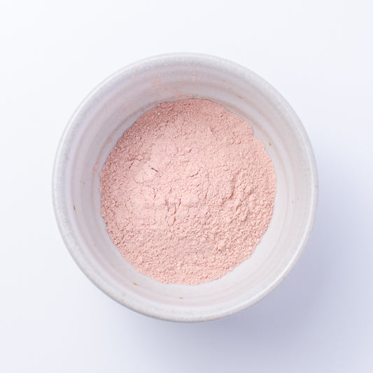 Top down view of Nourish Facial Grains in rose petal and hibiscus powder for scrub or mask.