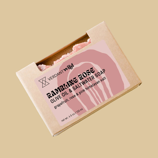 A kraft paper box of Verdant Wild Rose Olive Oil & Saltwater Soap, featuring a pink graphic, photographed on a clean background.