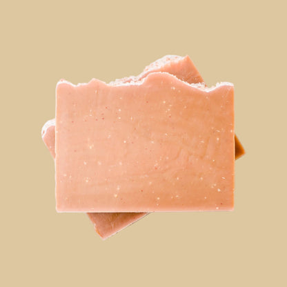 Two stacked rectangular bars of handmade soap in a dusty peach-pink, photographed from directly above on a clean background.