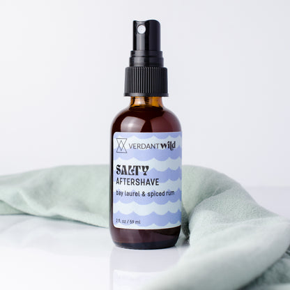aftershave bottle styled with towel on white background