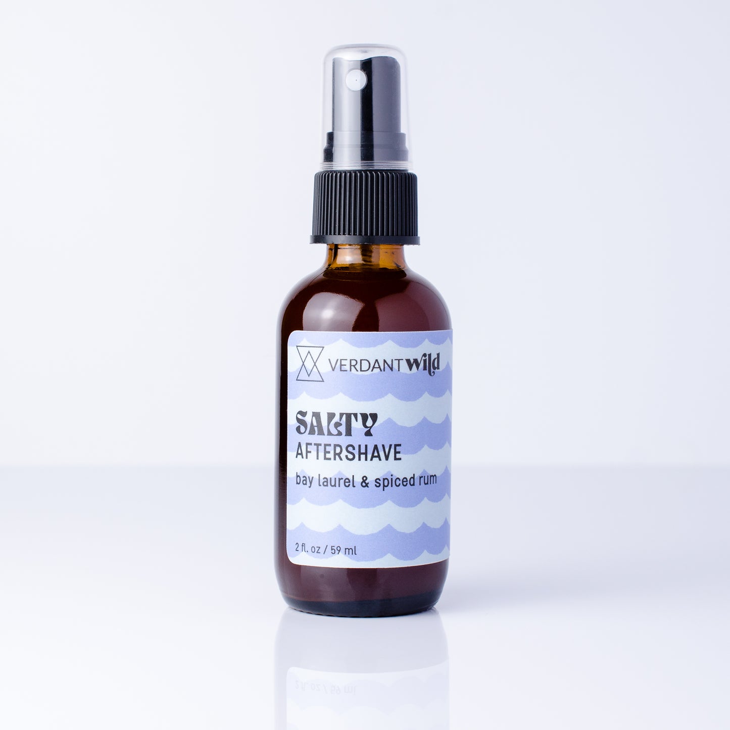 A 2 fl oz amber glass spray bottle of Verdant Wild Salty Aftershave with a black pump, set on a white background.