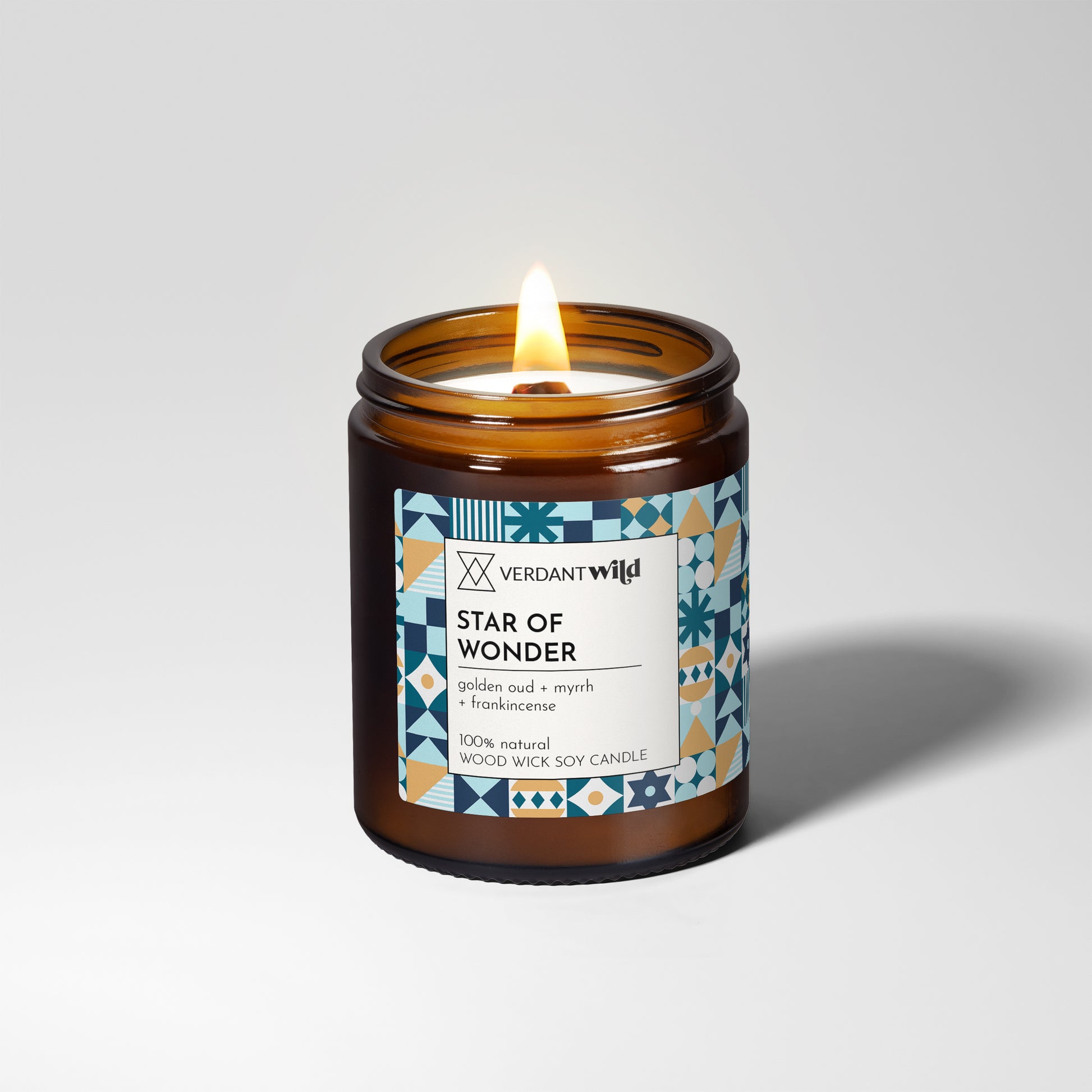 Candle in an amber jar with a decorative label on a light gray background