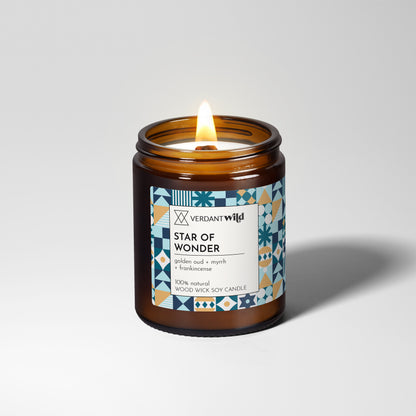 Candle in an amber jar with a decorative label on a light gray background