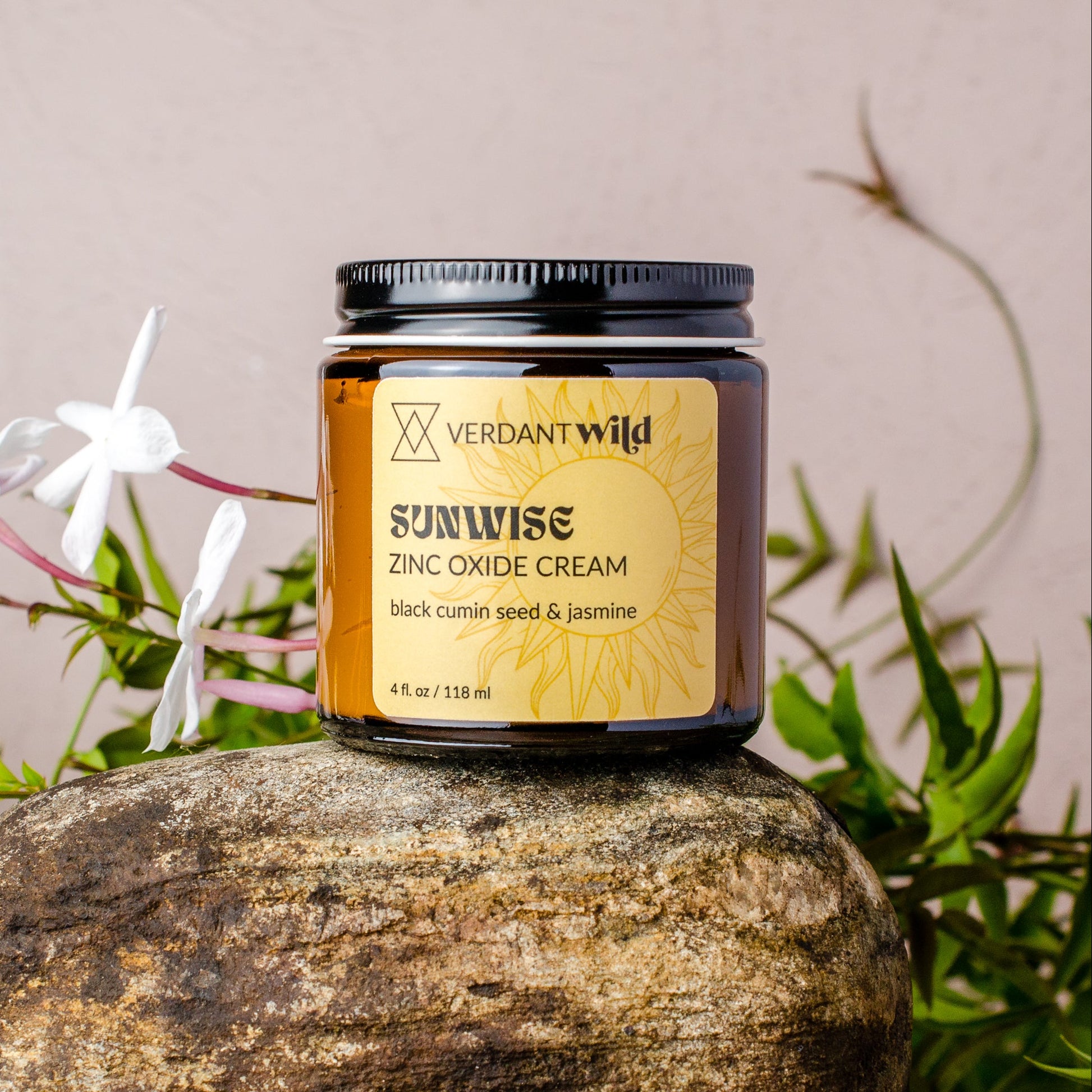 Jar of Verdant Wild Sunwise Zinc Oxide Cream on a rock with plants in the background
