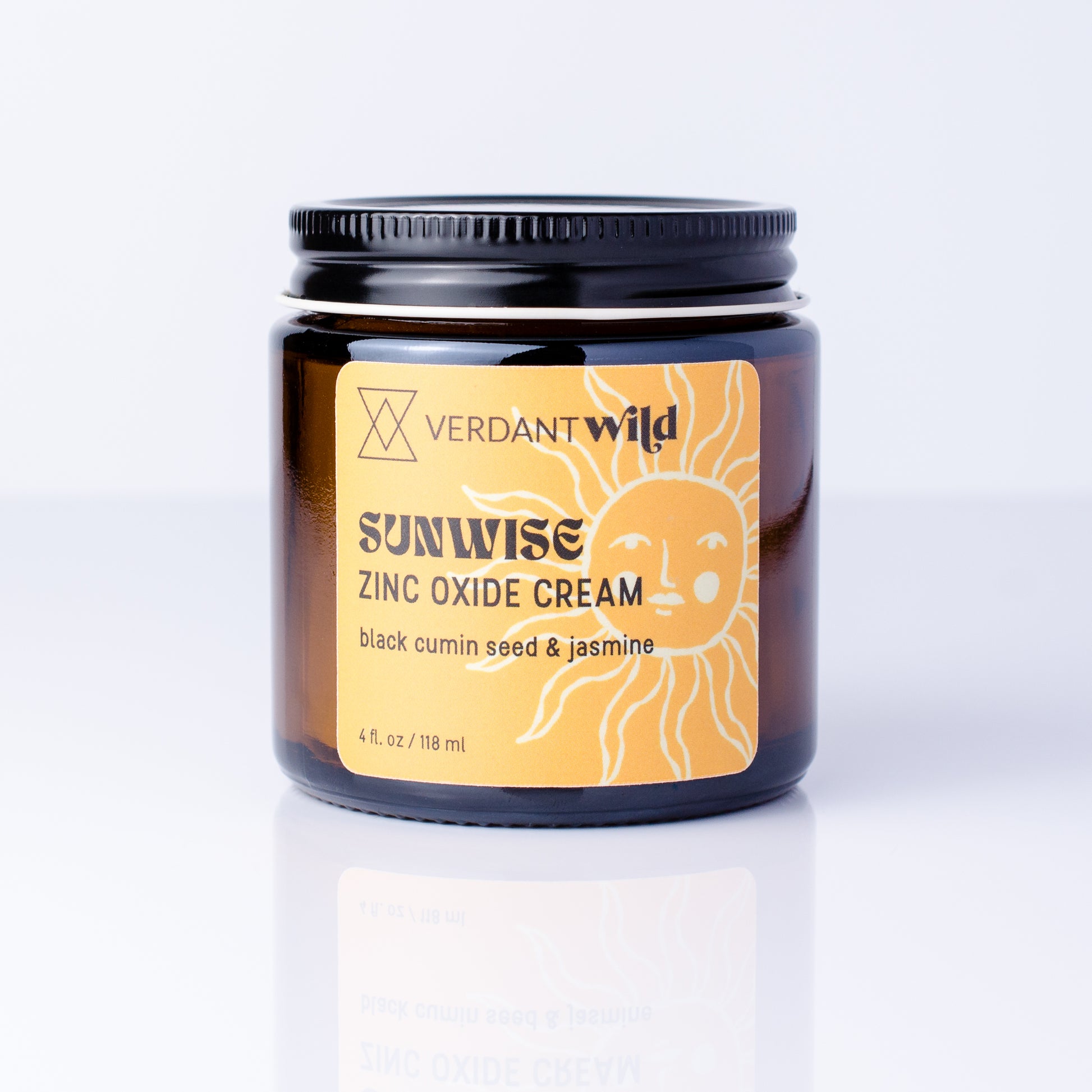A jar of Verdant Wild Sunrise Zinc Oxide Cream with a black lid and a yellow label featuring a sun illustration, set against a clean white background with a soft reflection.