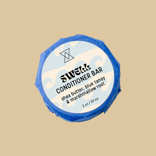 A round wrapped bar of Swell Conditioner soap on a clean background. The bar is wrapped in blue paper and features a white circular label with black text reading 'Swell Conditioner' and botanical line drawings.