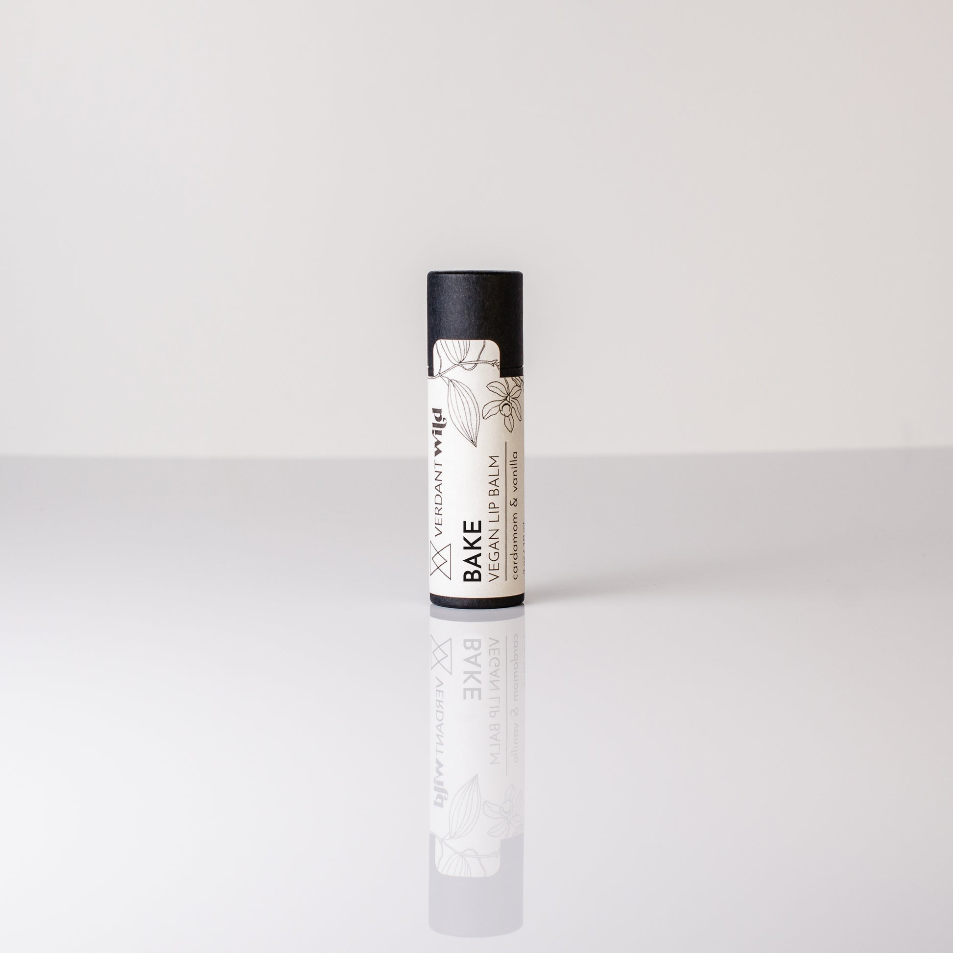 Lip balm with black and white packaging on a light gray background