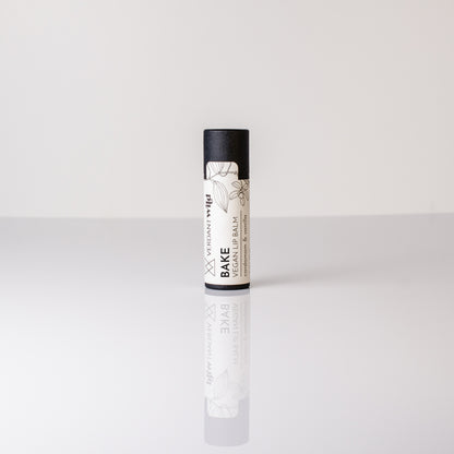 Lip balm with black and white packaging on a light gray background