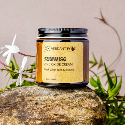 Jar of Verdant Wild Sunwise Zinc Oxide Cream on a rock with plants in the background