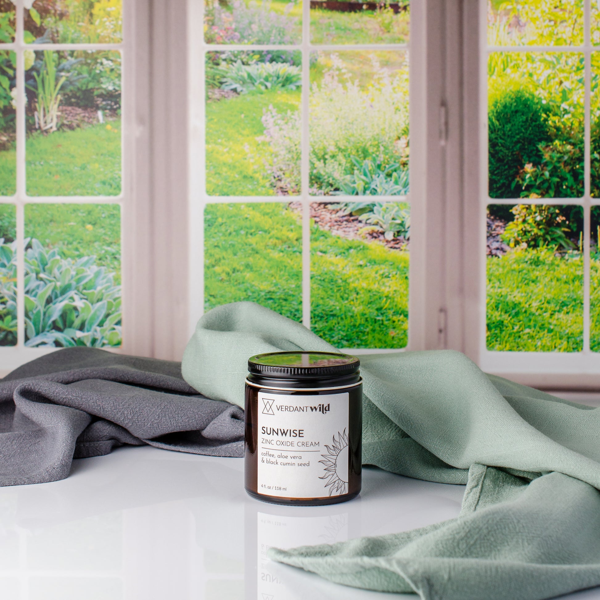 zinc oxide sun cream with coffee and black cumin seed oil on windowsill