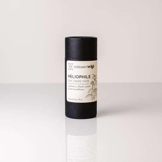 Black and white sunscreen stick with 'Verdant Wild' branding on a light gray background